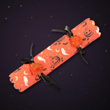 Pile of Halloween crackers with scalloped ends, witch hat and gold moon print