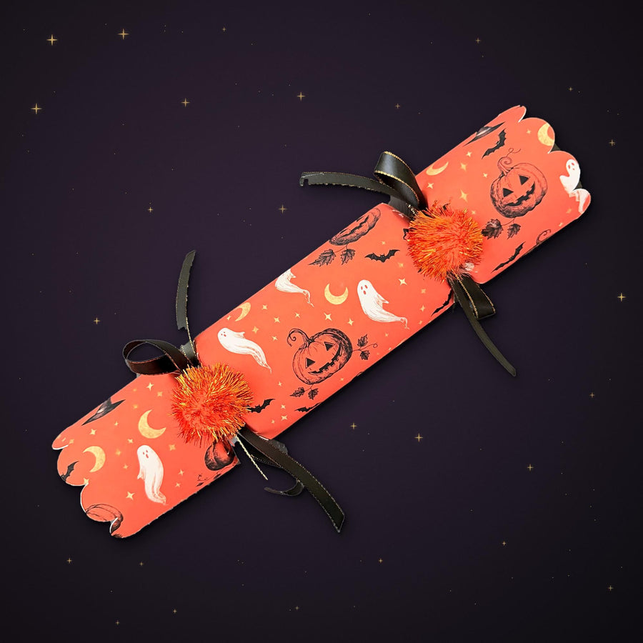 Pile of Halloween crackers with scalloped ends, witch hat and gold moon print