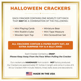 Folded paper crown party hats, a joke slip and a sticky hand toy taken out of the crackers