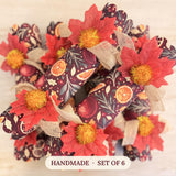 Set of six handmade Mulled and Merry crackers in a citrus and pomegranate print with red maple leaves and gold pom poms
