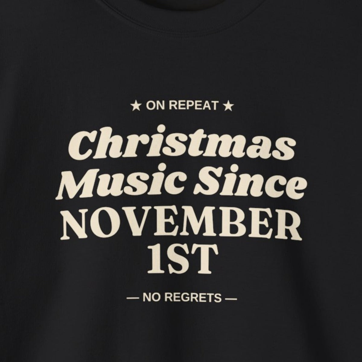 Close-up of the cream Christmas Music Since November 1st print on a black crewneck