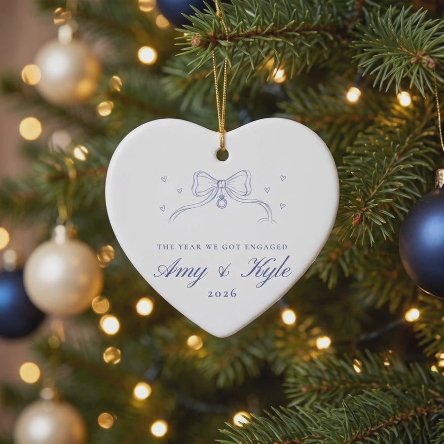 Personalized heart engagement ornament gently swaying on a lit Christmas tree