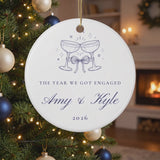 Personalized champagne toast engagement ornament gently swaying on a lit Christmas tree