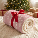 Personalized name blanket rolled and tied with a red ribbon under a Christmas tree as a gift