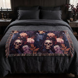 Questionably Cute skull and flowers woven blanket folded across the foot of a queen bed with charcoal linen