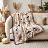 Subtle Spooky neutral Halloween woven blanket draped over a cream boucle sofa