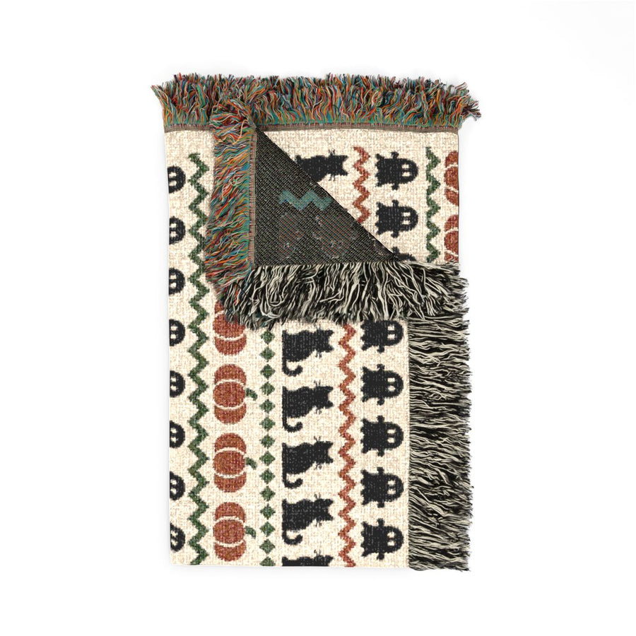 Haunted Heirloom woven blanket folded with one corner turned back to show the reverse side