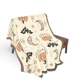 Subtle Spooky neutral Halloween woven blanket draped over a brown chair