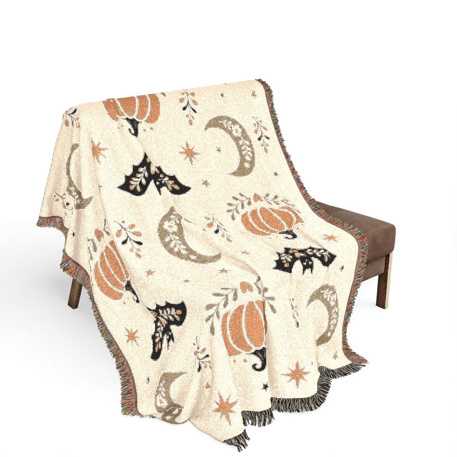 Subtle Spooky neutral Halloween woven blanket draped over a brown chair